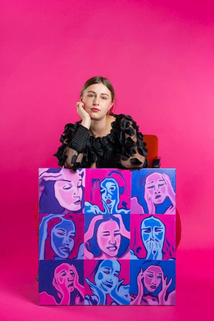 Salomé Quetier pose avec une de ses oeuvres originales en bichromie, un autoportrait intitulé "Palette"